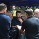 Australian Federal Police and Defense Force personnel talk each other near the cave entrance.